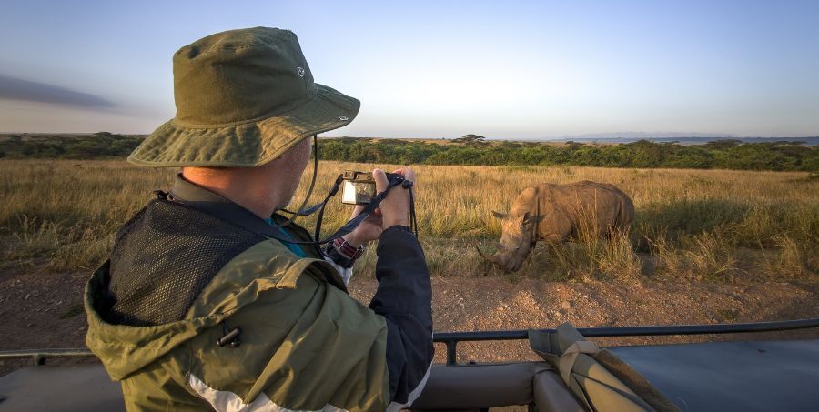 Man on safari  taking photo of rhino.jpg